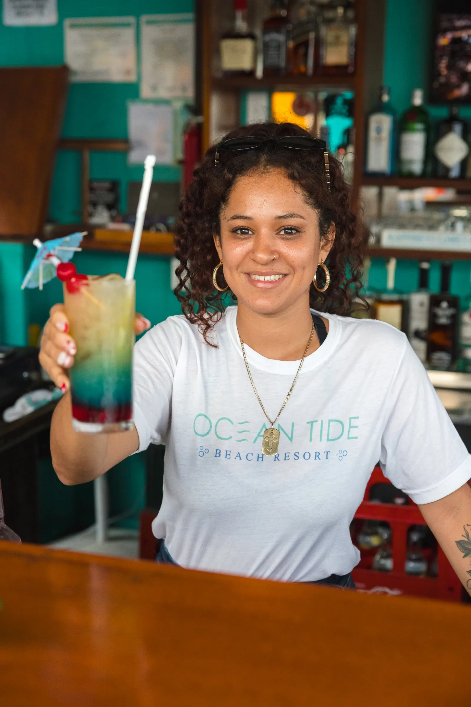 Bartender serving a layered sunrise cocktail at the Lazy Pelican